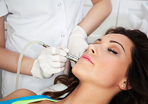 Woman getting laser face treatment in medical spa center, skin r